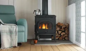 En mysig vrå med en sprakande kamin, vedhög och en bekväm fåtölj. En **mura skorsten** leder röken ut.
