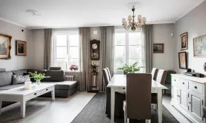Vardagsrum med soffa, matbord och en serveringsgång i sekelskiftesstil.