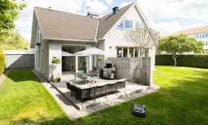 Grönskande trädgård med uteplats, grill och robotgräsklippare. Drömmen om billigaste husen i Sverige kan börja här!