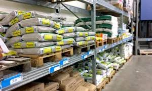 Stora lagerhyllor fyllda med säckar av byggmaterial, som bruk och cement, från kc bruk.