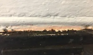 Detaljbild av en murstock som behöver målas. Fläckar och ojämnheter syns tydligt.