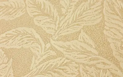 En beige tapet med ett mönster av stiliserade blad, typiskt för en tapet 1940-tal. Mönstret har en texturerad yta.