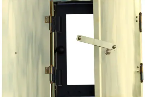 Brass doors of a fireplace insert, one open, showing a black interior with a white opening.