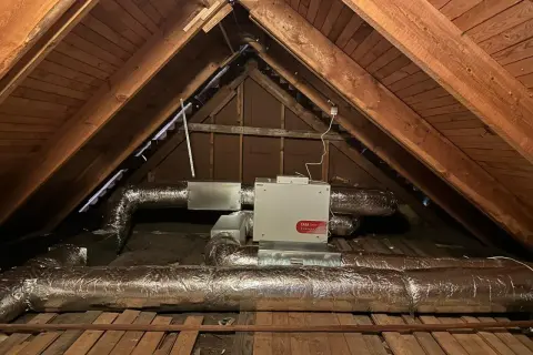 Ventilationsaggregat med filterklass F7 i en vind. Isolerade rör leder till och från enheten.