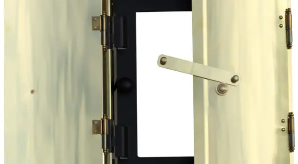Brass doors of a fireplace insert, one open, showing a black interior with a white opening.