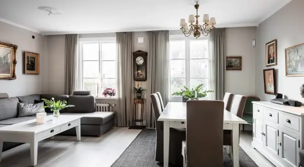Vardagsrum med soffa, matbord och en serveringsgång i sekelskiftesstil.