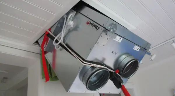 Ett FTX-aggregat vindmonterat i taket. Enheten är av märket HERU och har anslutningar för ventilation.