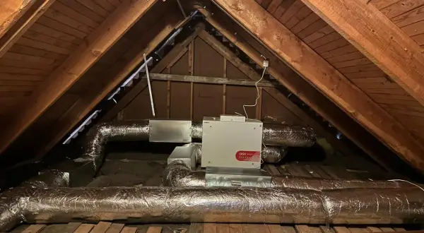 Ventilationsaggregat med filterklass F7 i en vind. Isolerade rör leder till och från enheten.