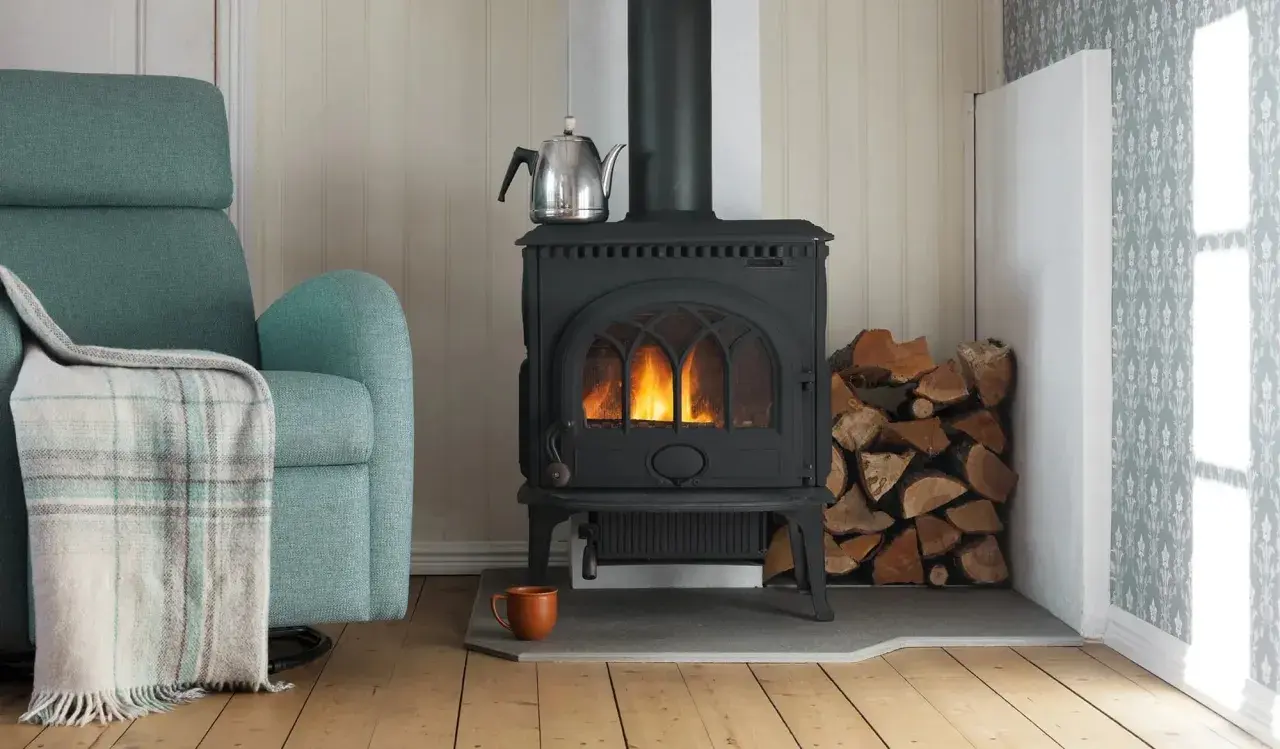 En mysig vrå med en sprakande kamin, vedhög och en bekväm fåtölj. En **mura skorsten** leder röken ut.