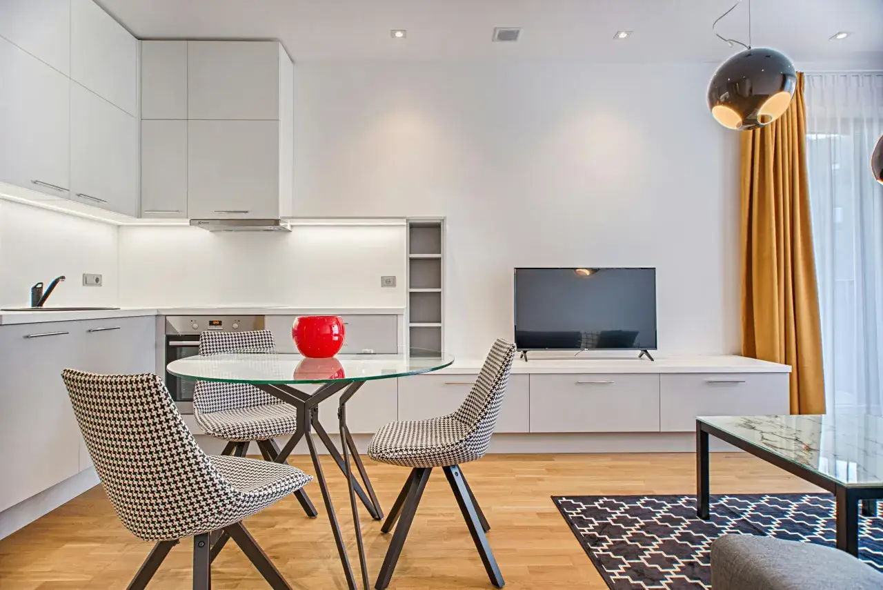 Modernt vardagsrum med köksdel, matbord med glas och mönstrade stolar. Perfekt för den som vill renovera vardagsrum.