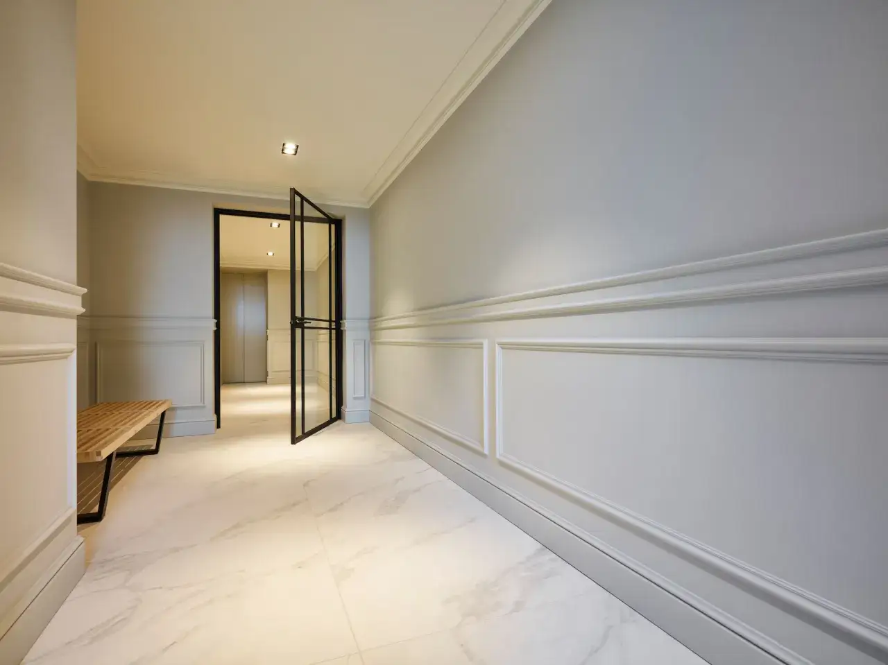 Elegant hall med stuckatur vardagsrum, marmorgolv och en öppen glasdörr.