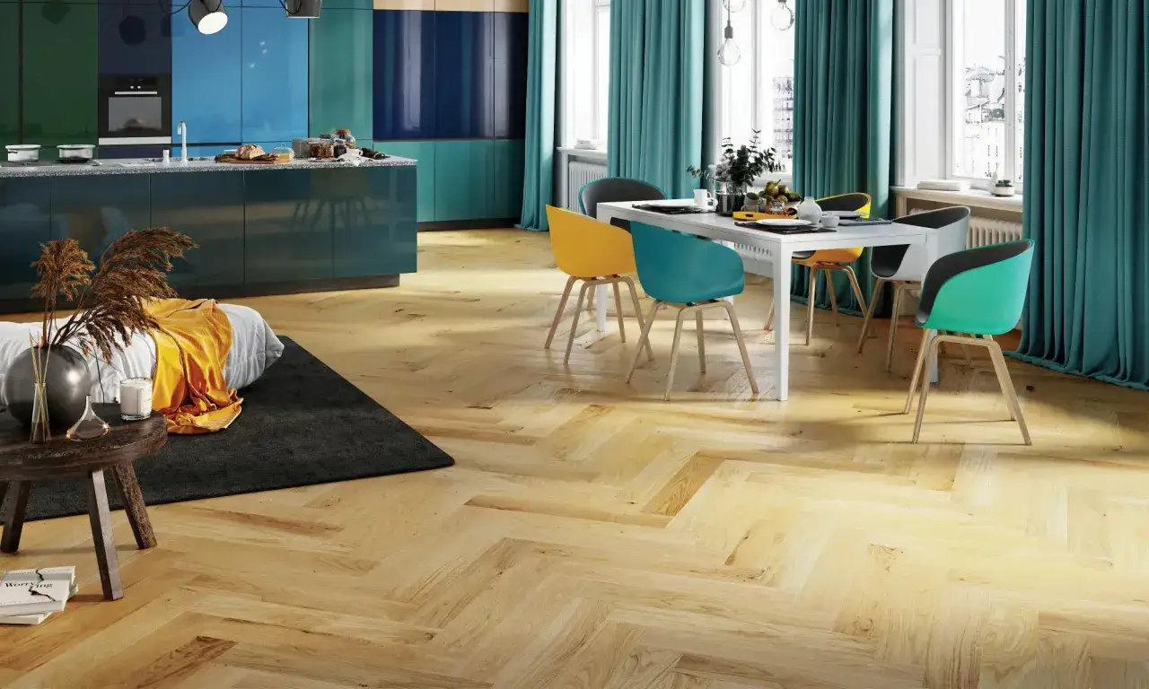 Vacker fiskbensparkett i ljust tr&auml; ger en varm k&auml;nsla. T&auml;nk p&aring; kostnad fiskbensparkett vid renovering. Modernt k&ouml;k och matplats med f&auml;rgglada stolar.